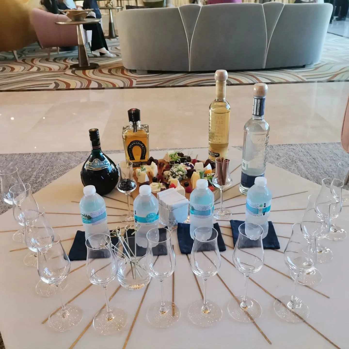 Mesa de degustación con copas, botellas y pequeños utensilios para preparar bebidas.