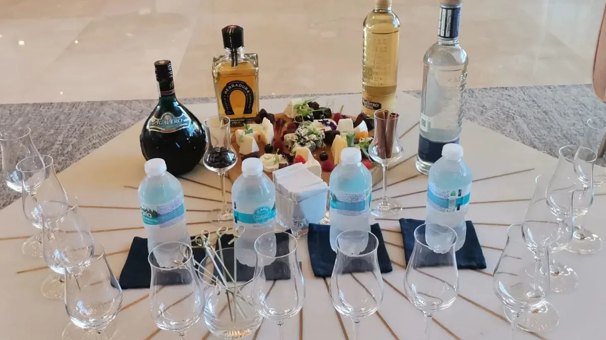 Mesa de degustación con copas, botellas y pequeños utensilios para preparar bebidas.